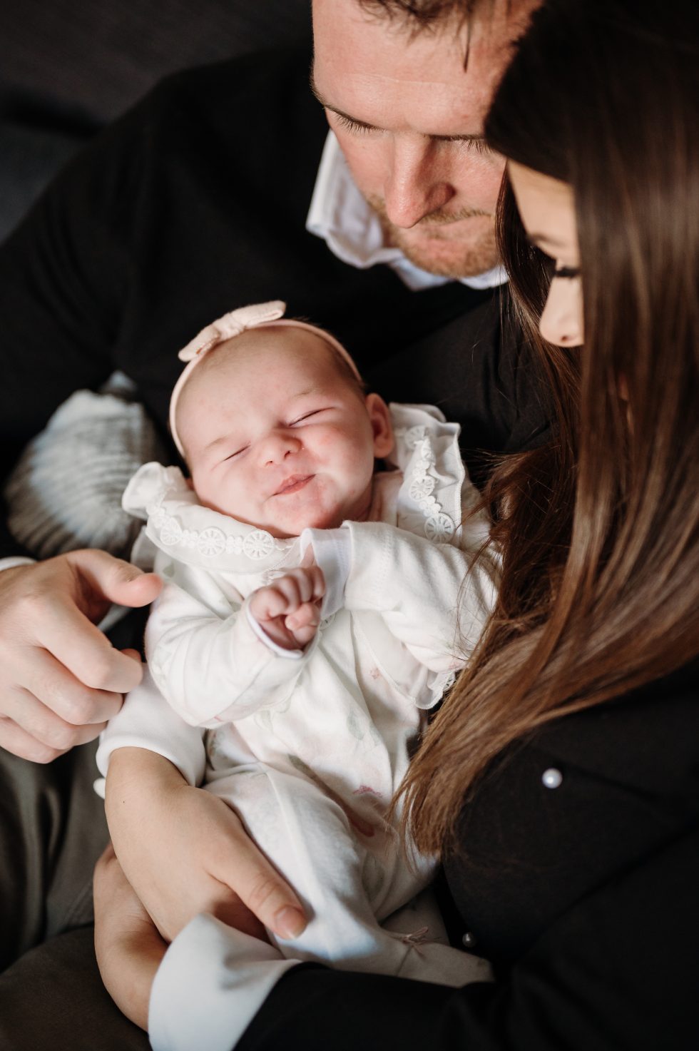 New mum and dad looking at their daughter