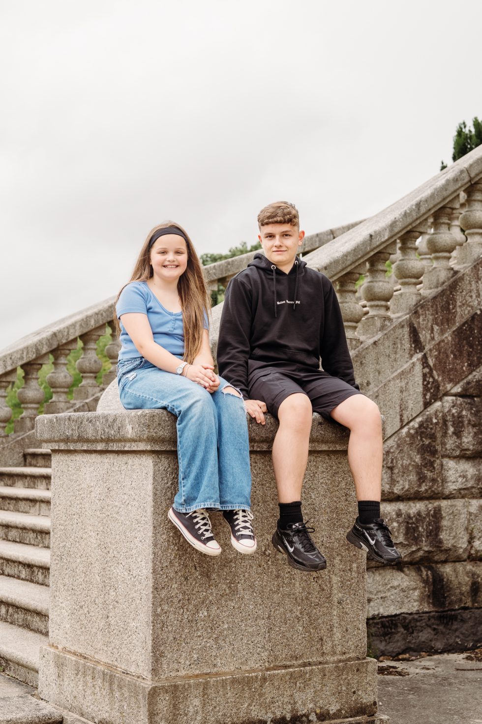 Brother and sister sat on a wall at Williamson Park for a photo shoot with Lancashire family photographer