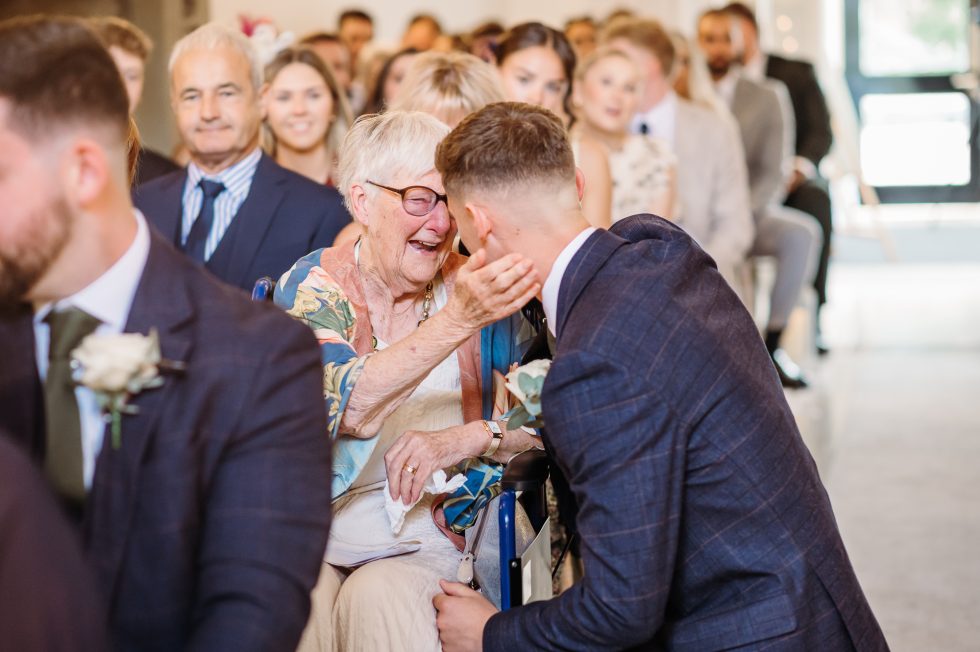 Groom giving his emotional grandma a cuddle by stirk house wedding photographer