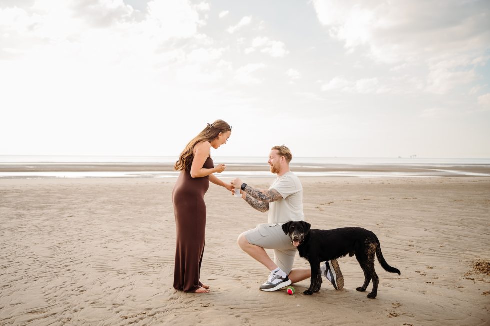 Lancashire Beach Proposal Shoot. Man is down on one knee asking his beautiful girlfriend to marry him