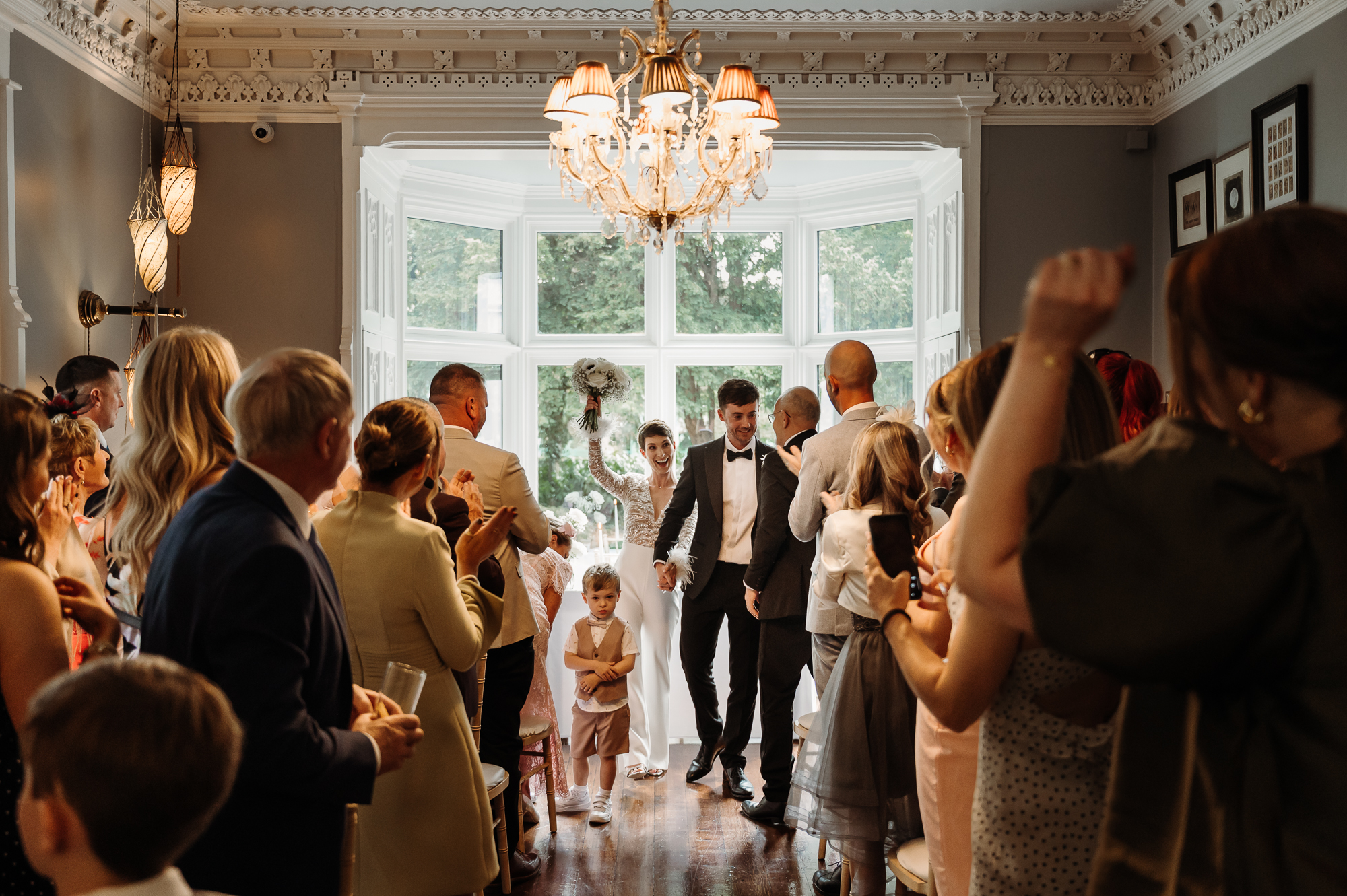 Bride and groom just after they got married at Didsbury House. Bride is holding her bouquet in the air