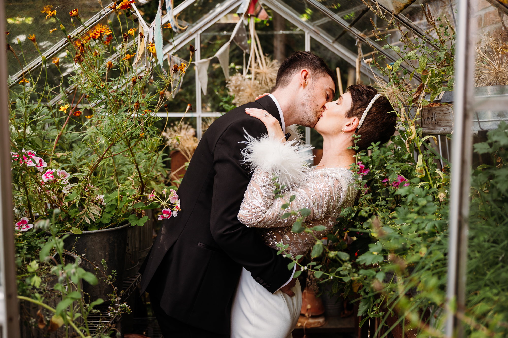 Bride and groom during a dip kiss in the greenhouse at Eleven by Didsbury House wedding Photographer
