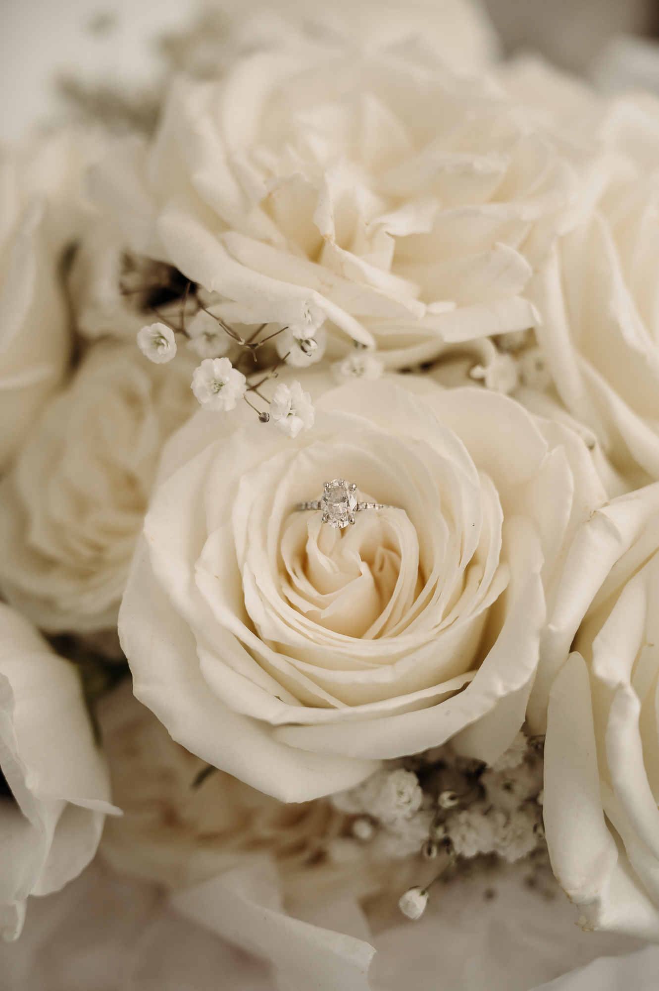 Detailed shot of engagement ring in a white rose wedding bouquet