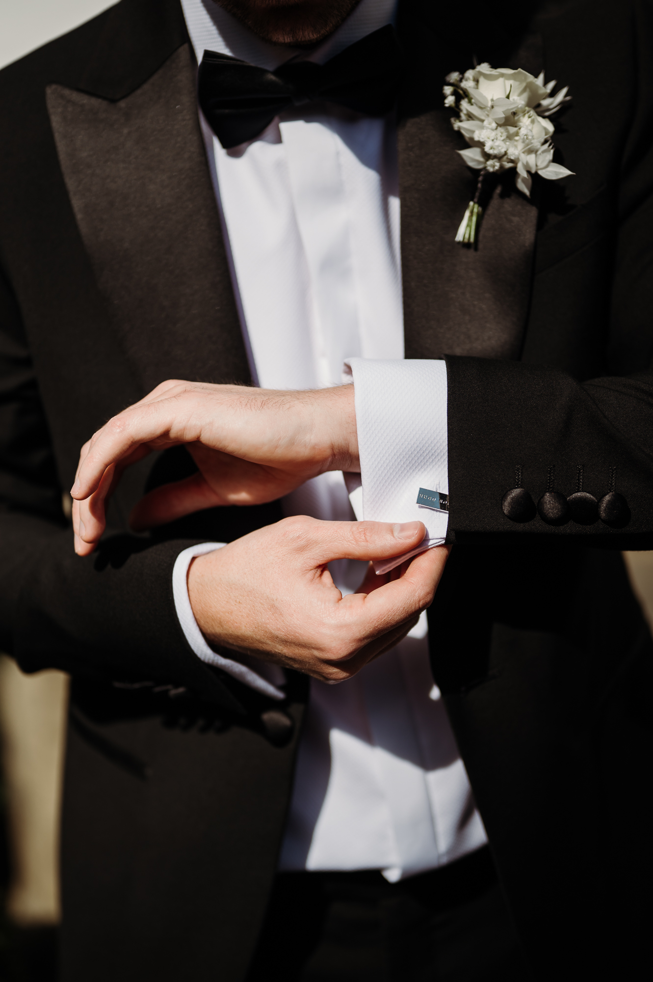 Groom putting on his cufflinks