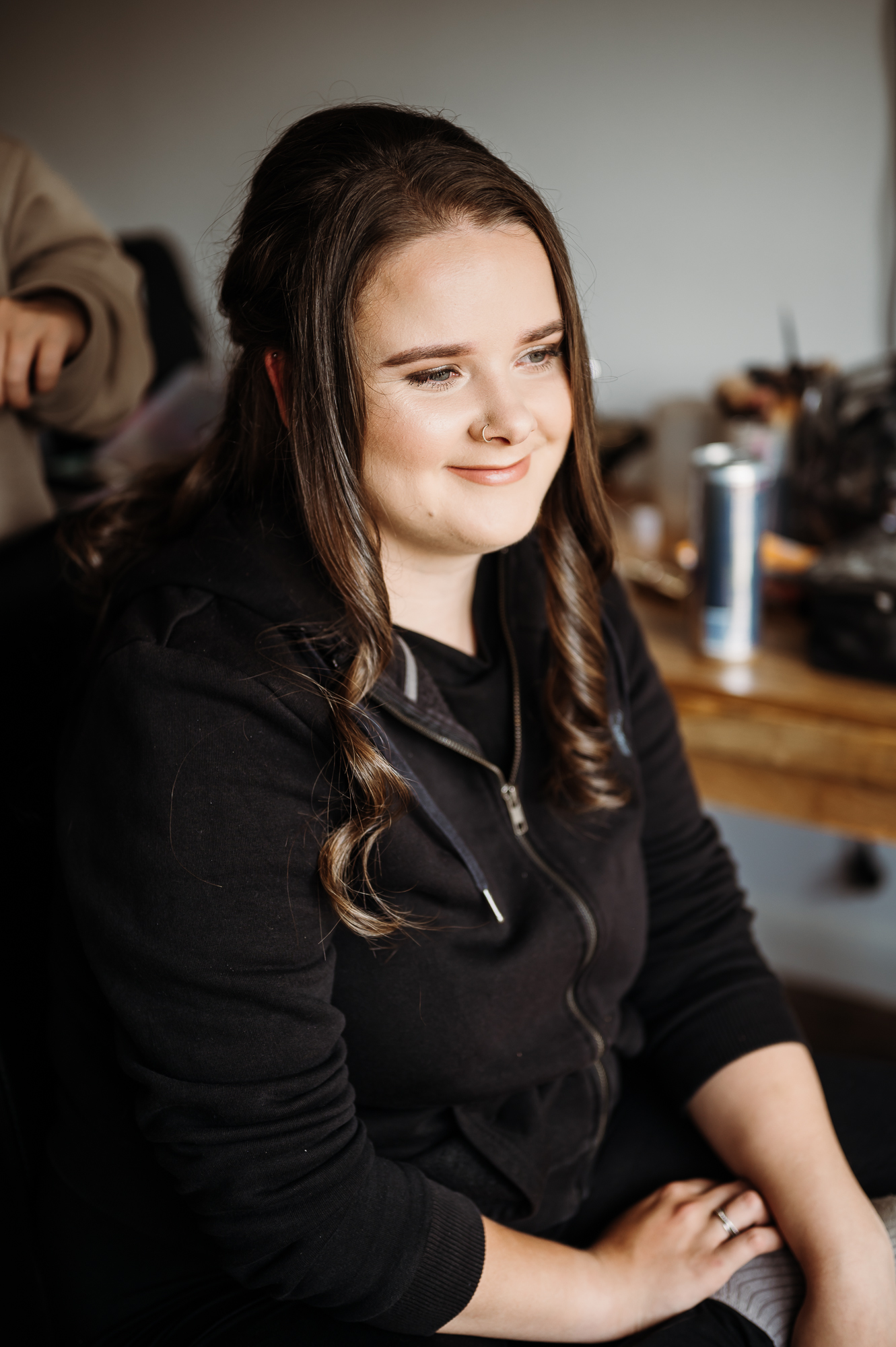 Brunette bride having her hair done. She is smiling