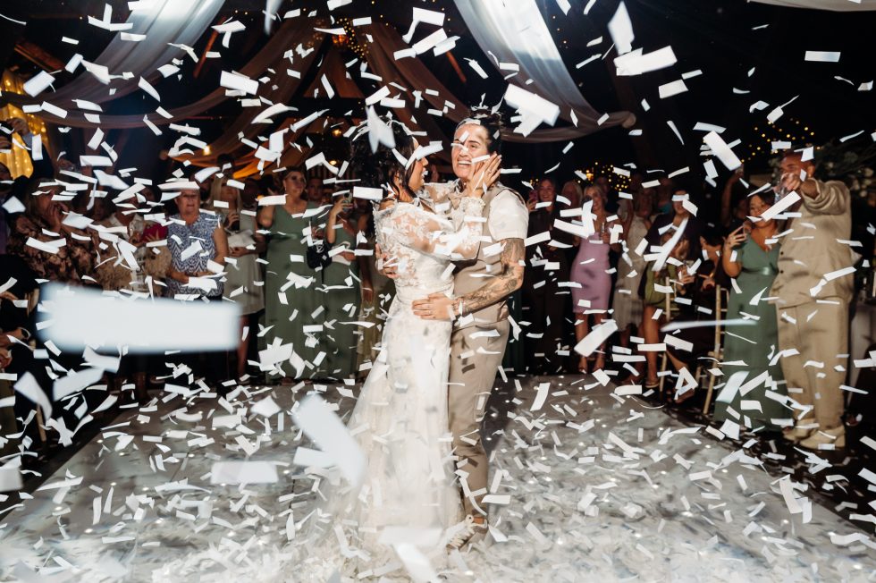 First dance and Mrs & Mrs and white confetti is falling all around them by Rivington Hall Barn wedding Photographer