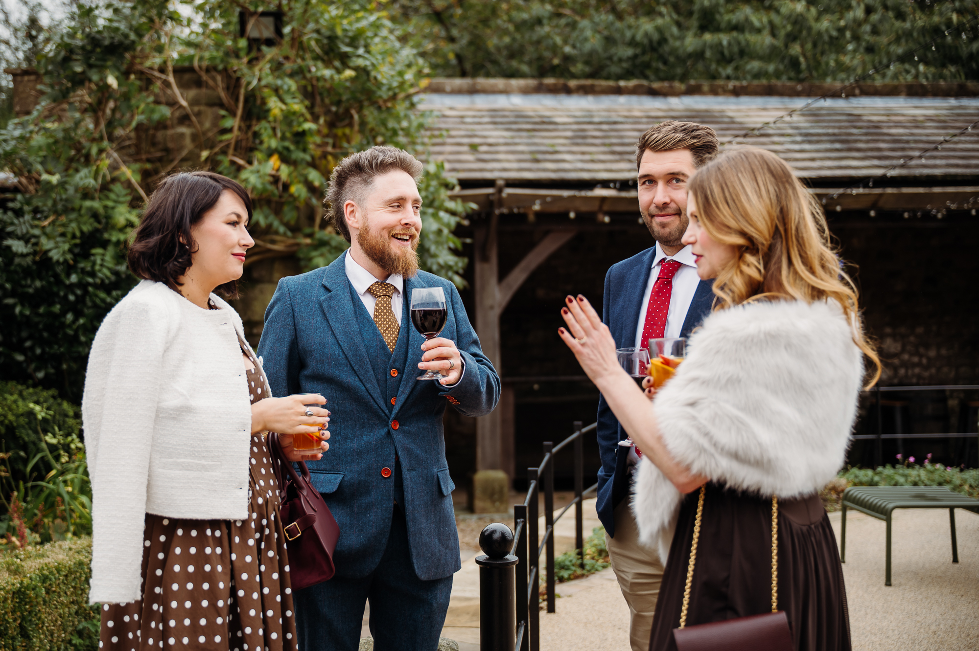 Wedding guests enjoying a drink in the courtyard at Browsholme Hall.